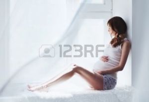 14330277-jeune-femme-enceinte-assise-sur-la-fen-tre